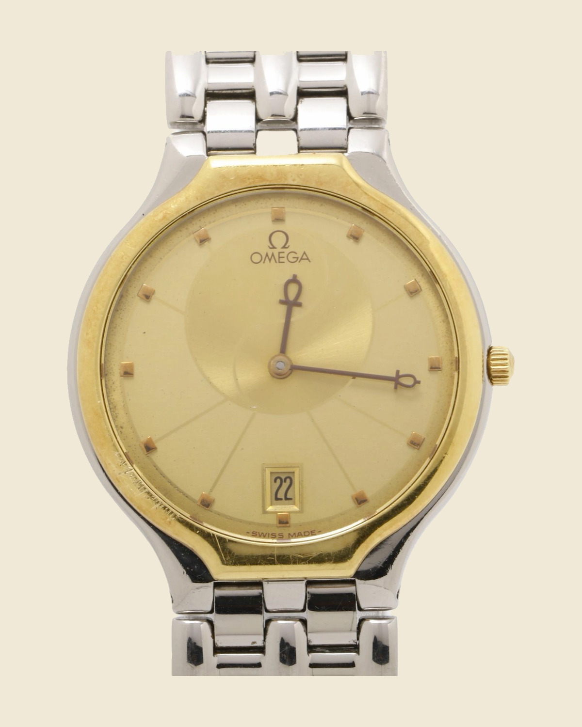 Orologio Omega in acciaio con quadrante champagne, datario a ore 6, lunetta dorata e bracciale a maglie integrato