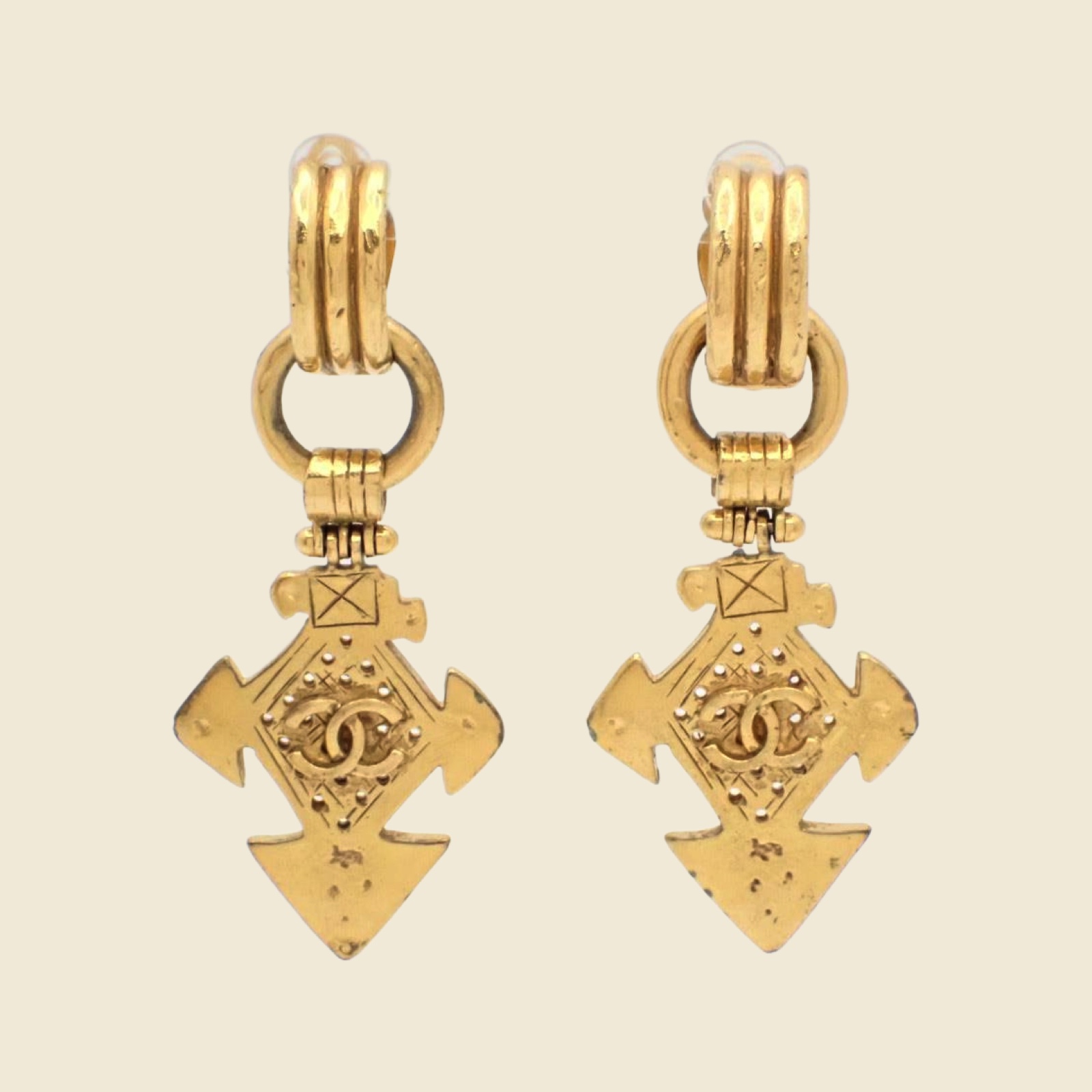 Orecchini a clip Chanel pendenti in metallo dorato, placca a croce con logo CC al centro, vista frontale