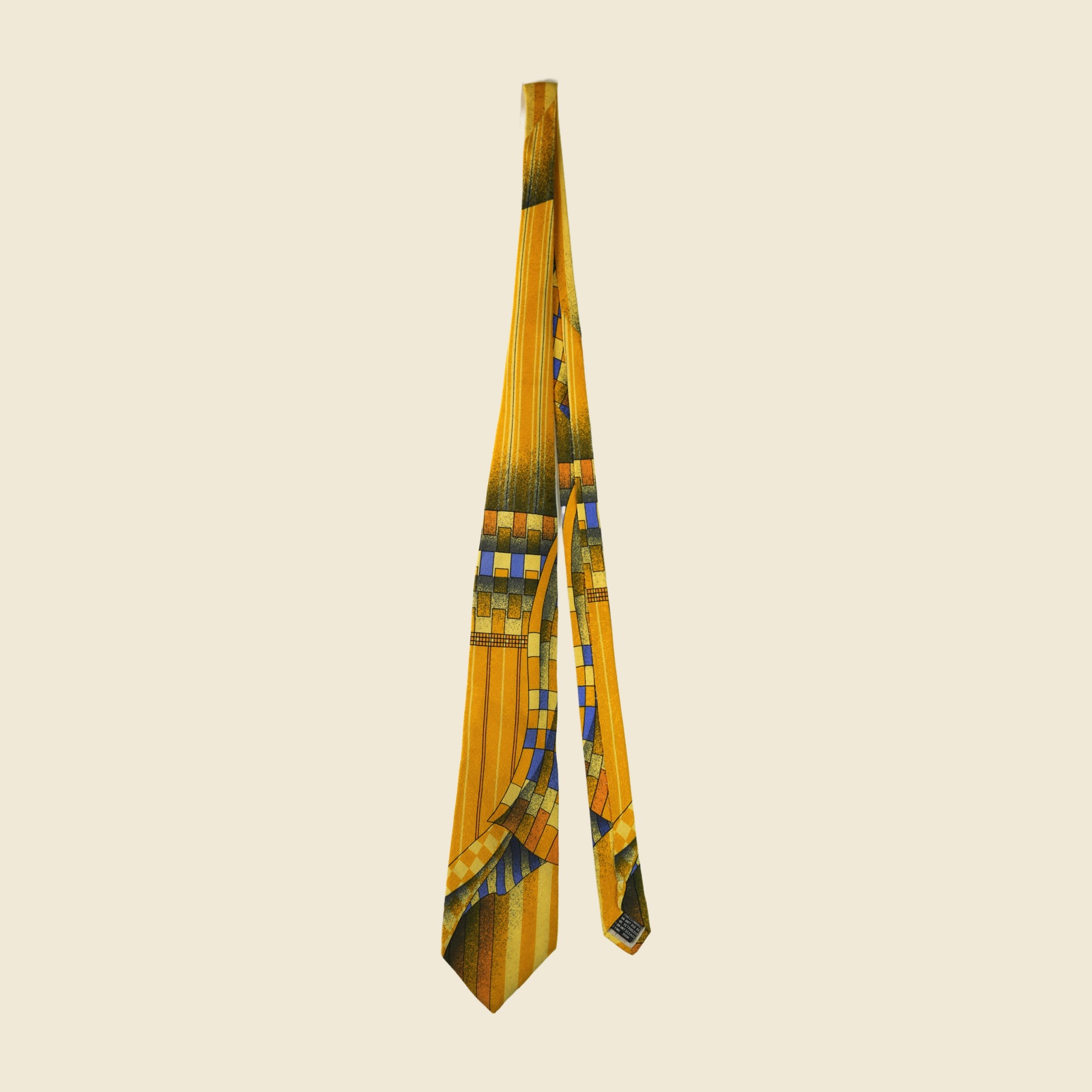 Cravatta Gianni Versace in seta giallo senape con stampa geometrica astratta blu e ruggine, su fondo bianco — vista 2