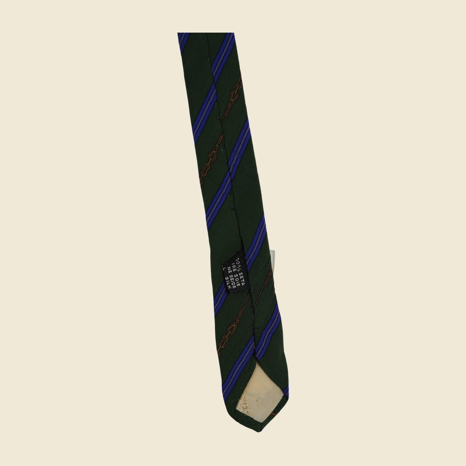 Cravatta regimental Christian Dior in seta verde bosco, con banda blu cobalto a filetto lilla e riga oro a catena, distesa su fondo neutro