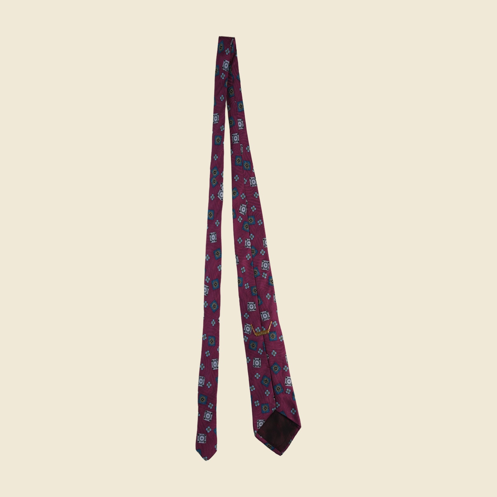 Cravatta Brioni in seta magenta prugna con medaglioni jacquard tessuti in oro, azzurro e ottanio, vista frontale su fondo neutro — vista 2