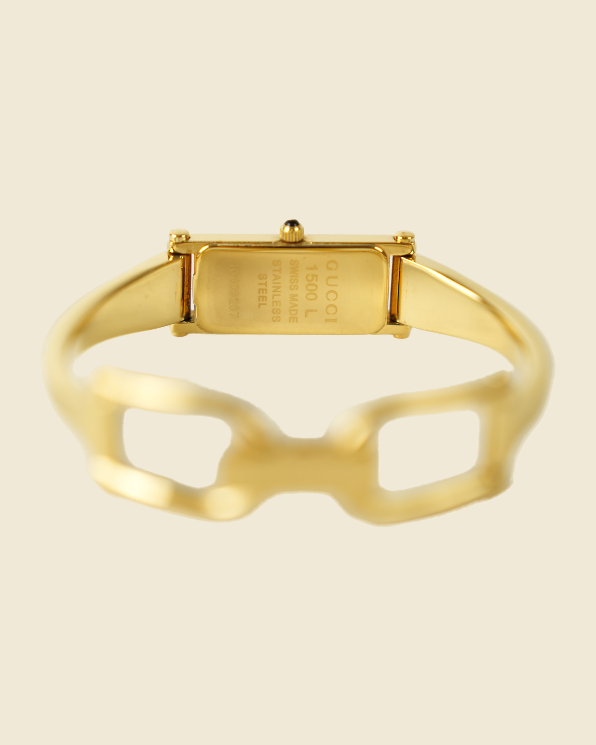 Orologio Gucci bangle in metallo dorato con morsetto sul bracciale e quadrante rettangolare, vista frontale su fondo neutro