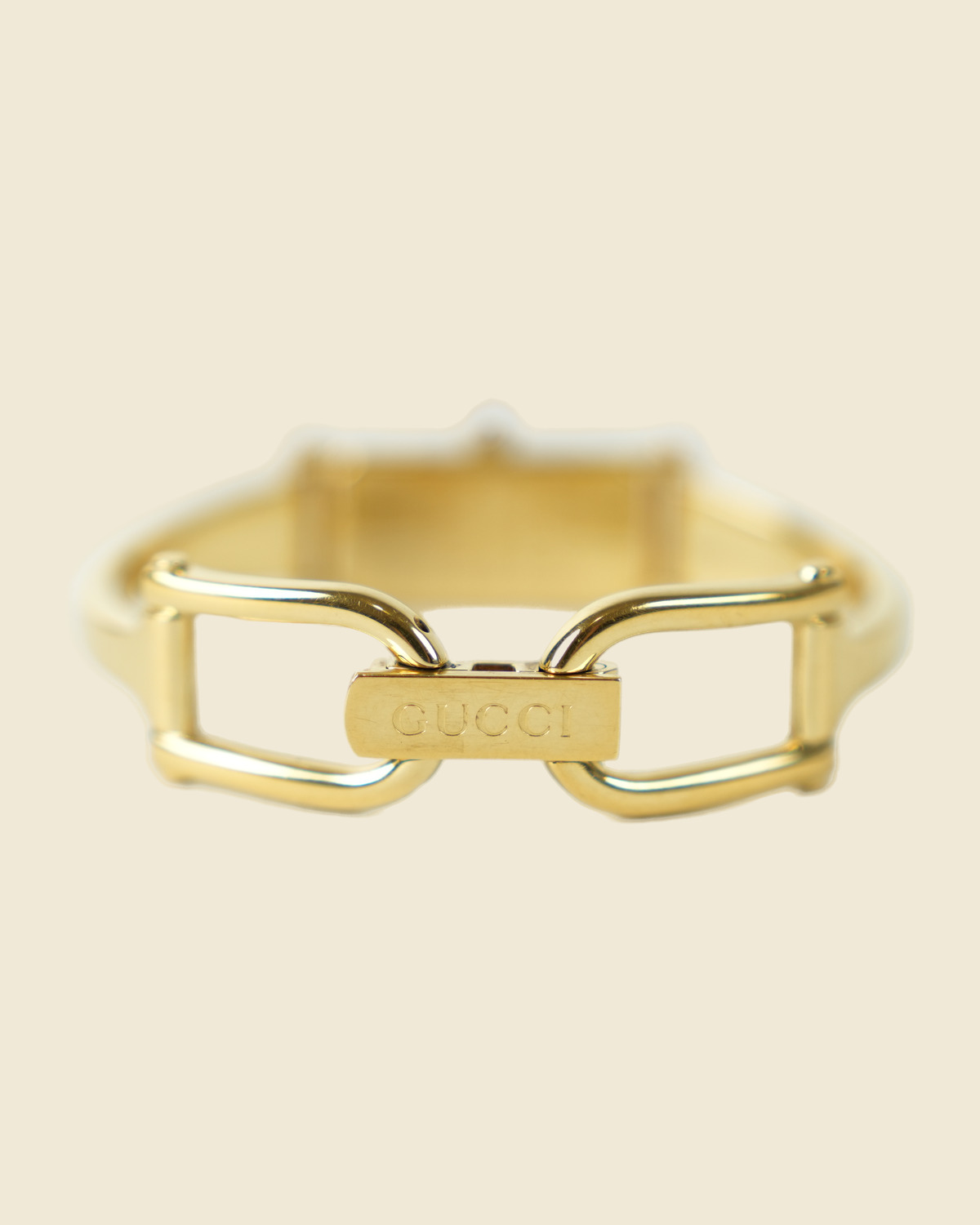 Orologio Gucci bangle in metallo dorato con morsetto sul bracciale e quadrante rettangolare, vista frontale su fondo neutro — vista 2