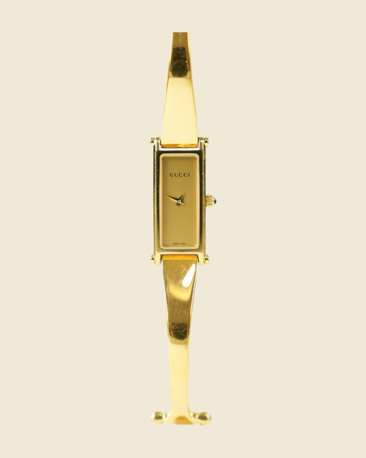 Orologio Gucci bangle in metallo dorato con morsetto sul bracciale e quadrante rettangolare, vista frontale su fondo neutro — vista 3