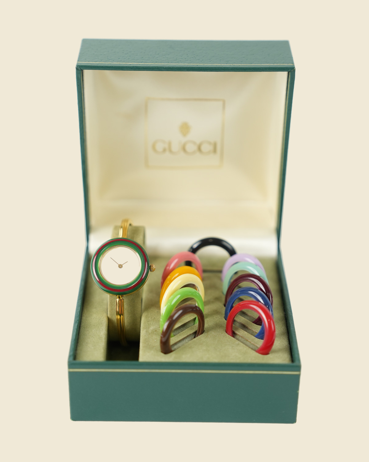 Orologio Gucci dorato con quadrante bianco e ghiera verde e rossa, nella scatola con il corredo di ghiere colorate