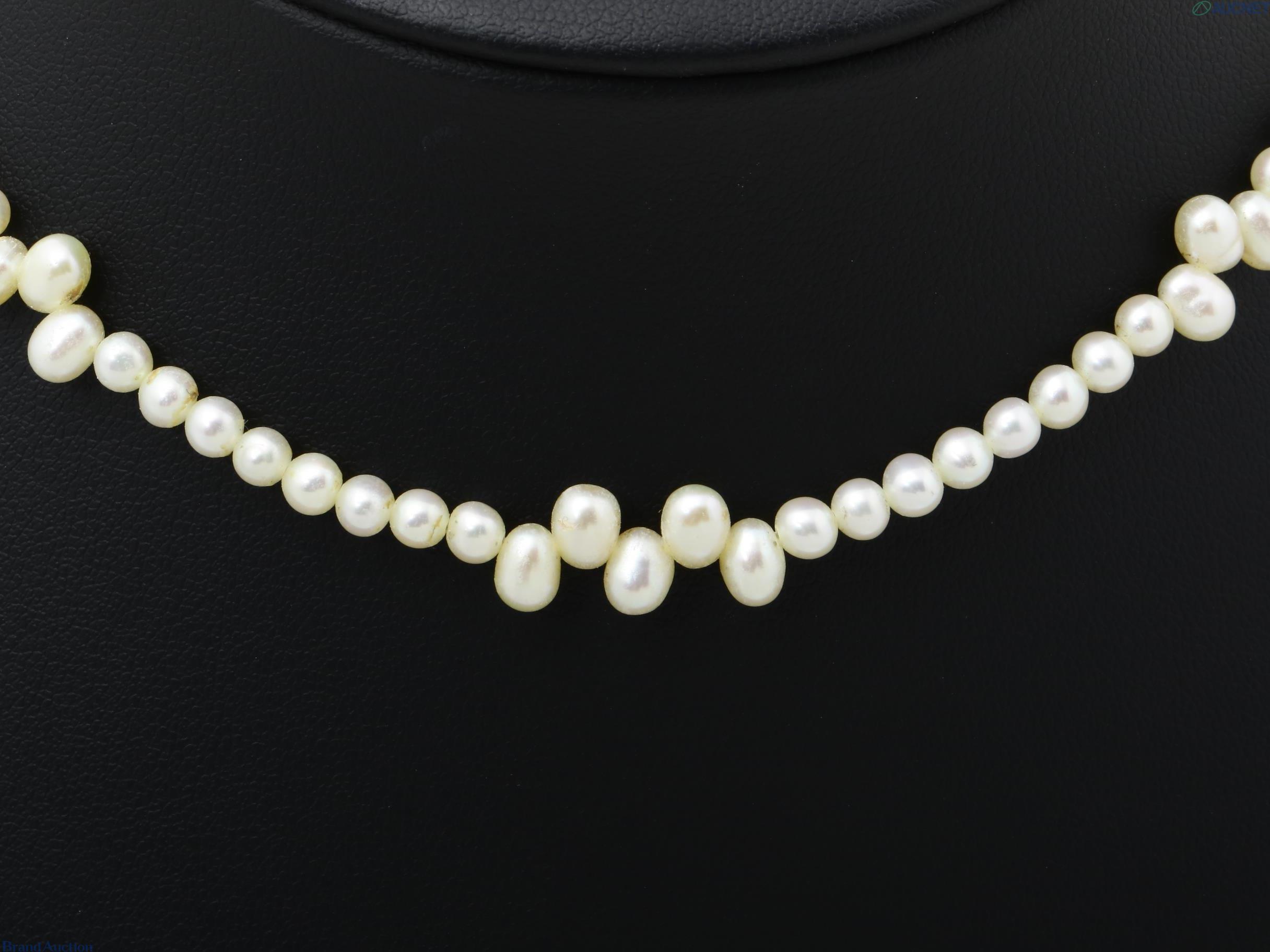 Collana di perle color avorio, piccole perle tonde con tre gruppi di perle a goccia, su espositore nero