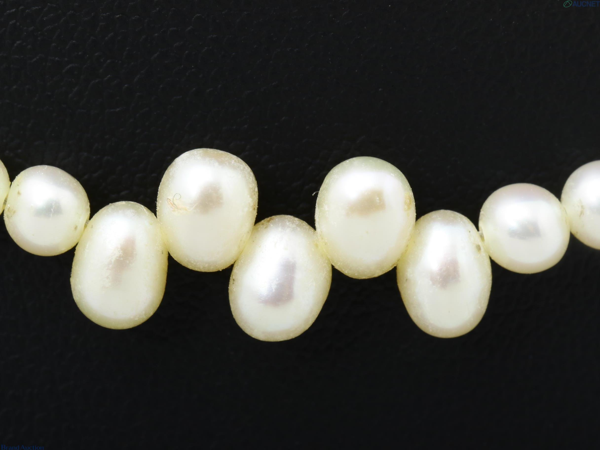 Collana di perle color avorio, piccole perle tonde con tre gruppi di perle a goccia, su espositore nero — vista 2