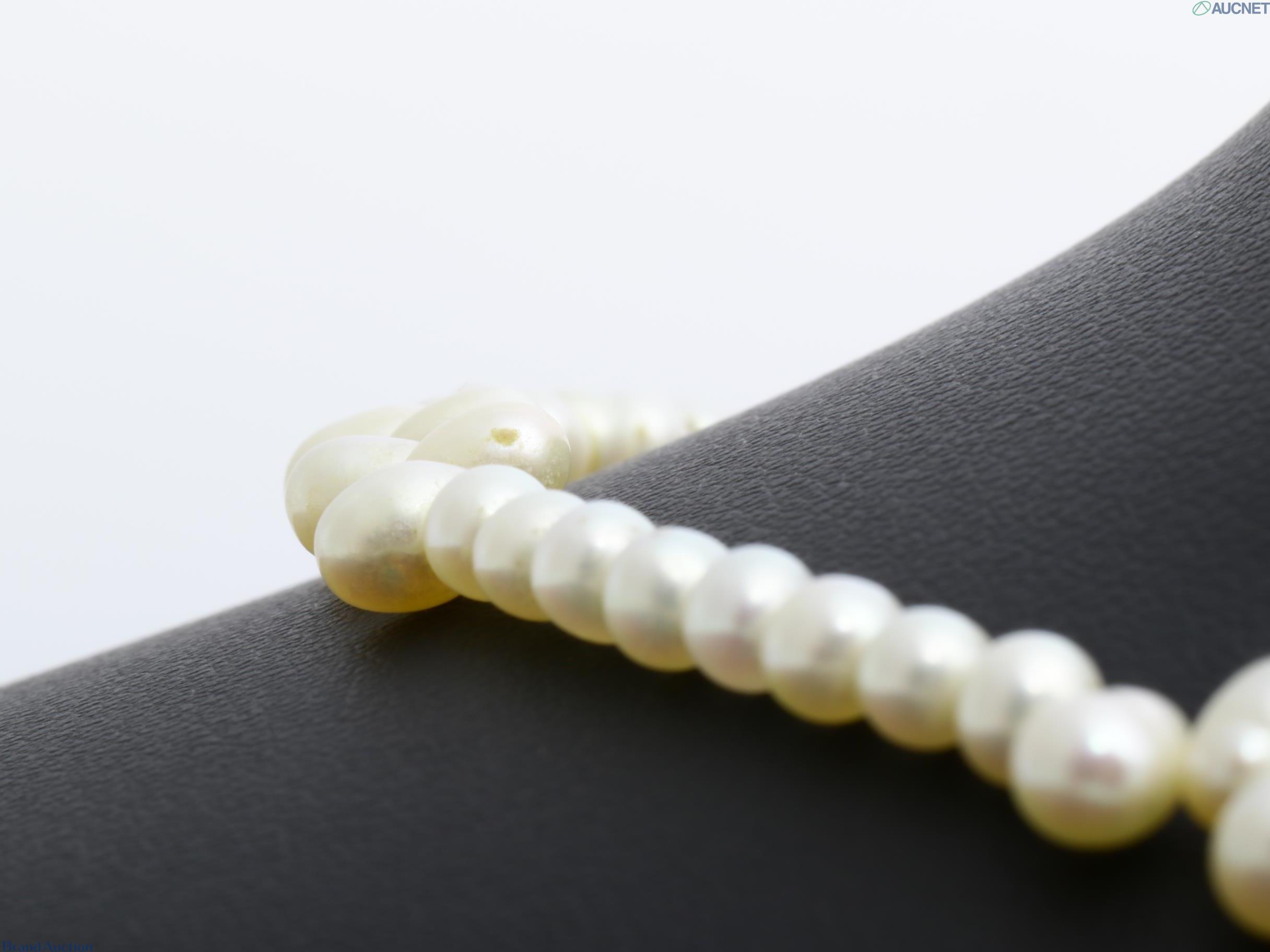 Collana di perle color avorio, piccole perle tonde con tre gruppi di perle a goccia, su espositore nero — vista 3