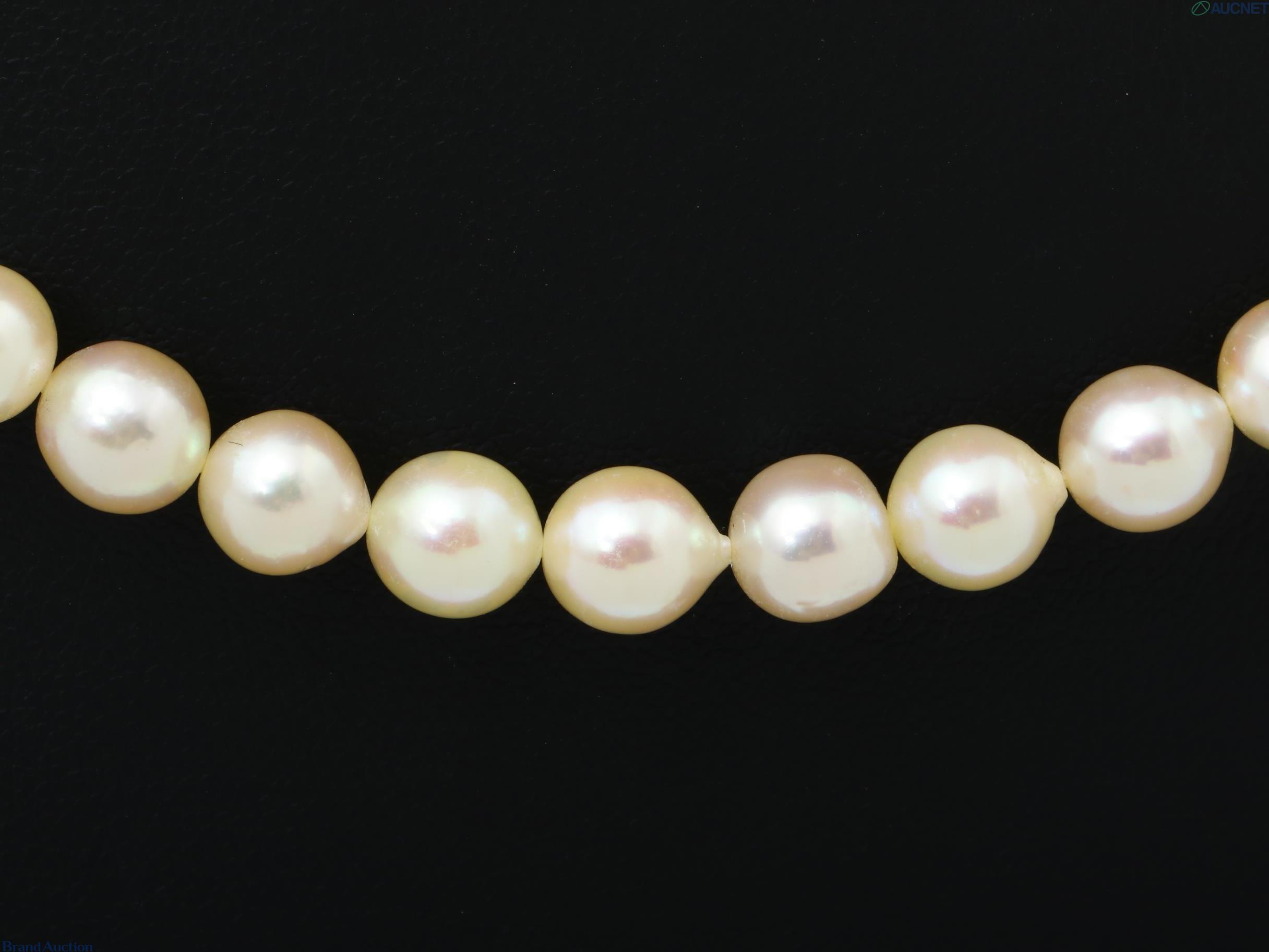 Collana a filo unico di perle barocche color crema dai riflessi rosati, su espositore nero