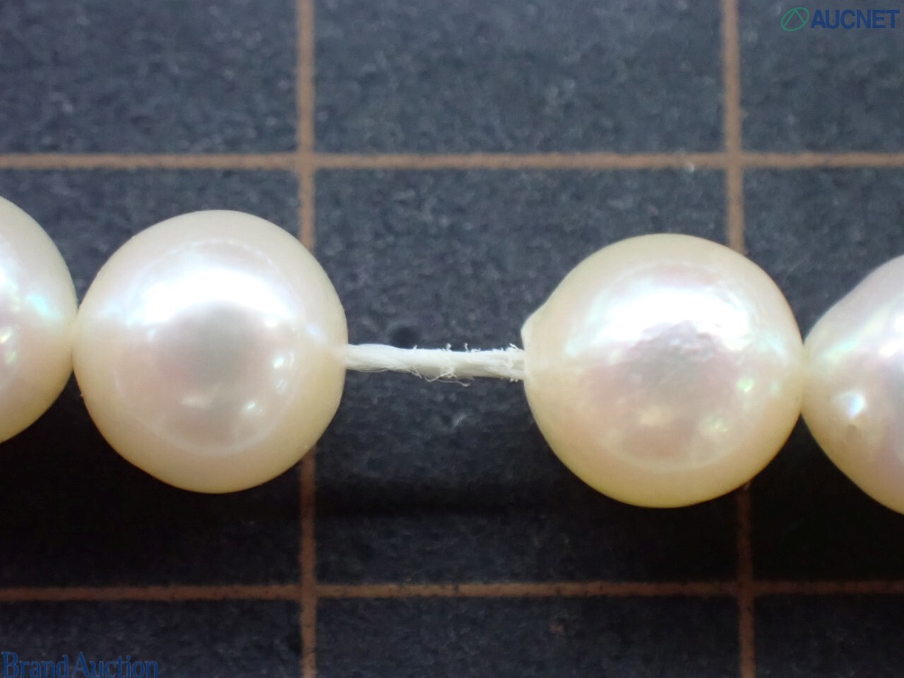 Collana a filo unico di perle barocche color crema dai riflessi rosati, su espositore nero — vista 8