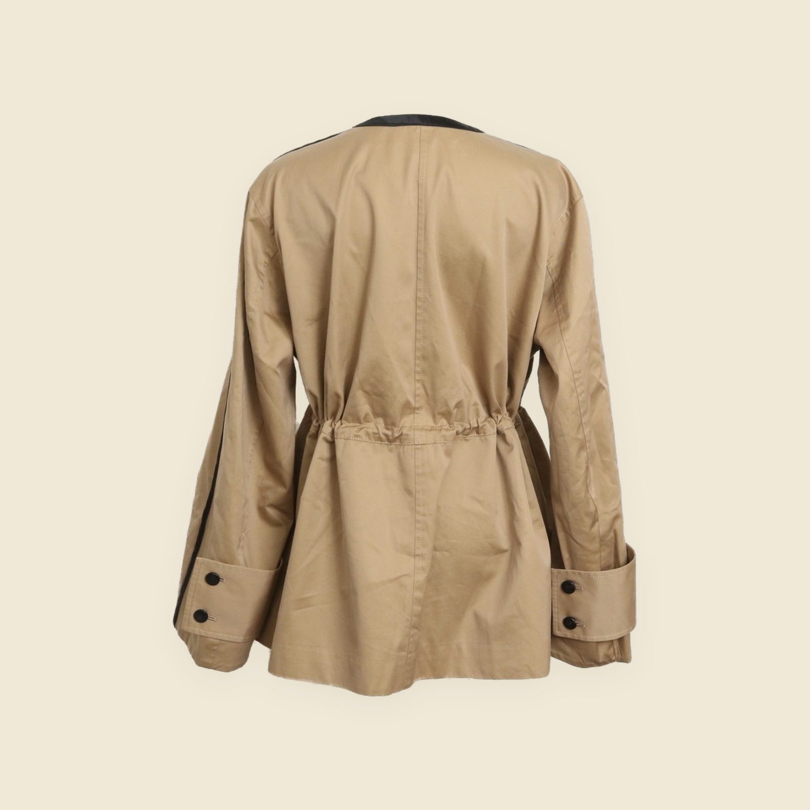 Giacca Cinoh beige senza collo su manichino, con profili neri al girocollo e lungo l'apertura e quattro tasche con pattina — vista 4