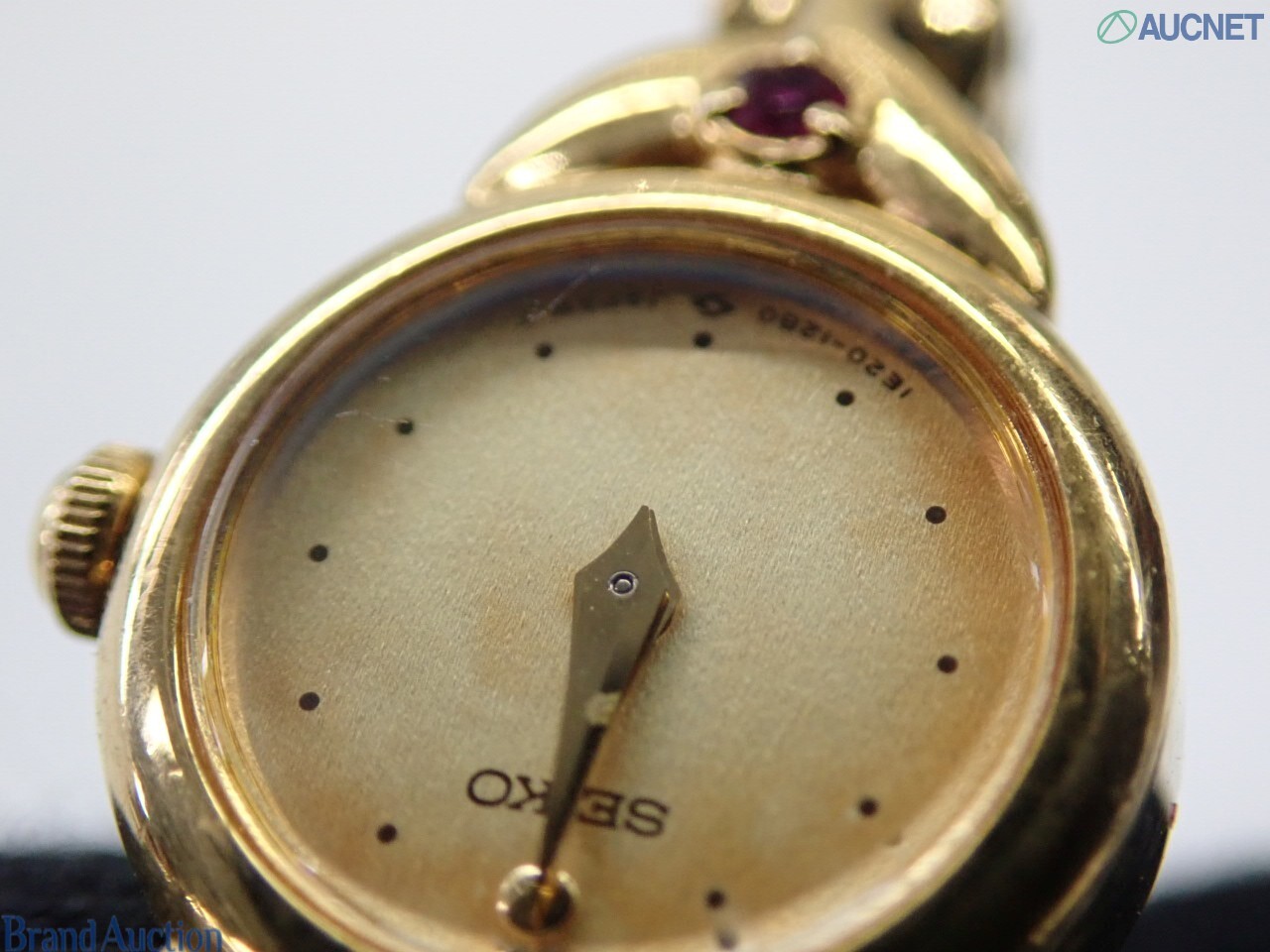 Orologio da donna Seiko color oro visto dal retro: fondello in acciaio, pietre rosse sulle anse, bracciale a catena — vista 2