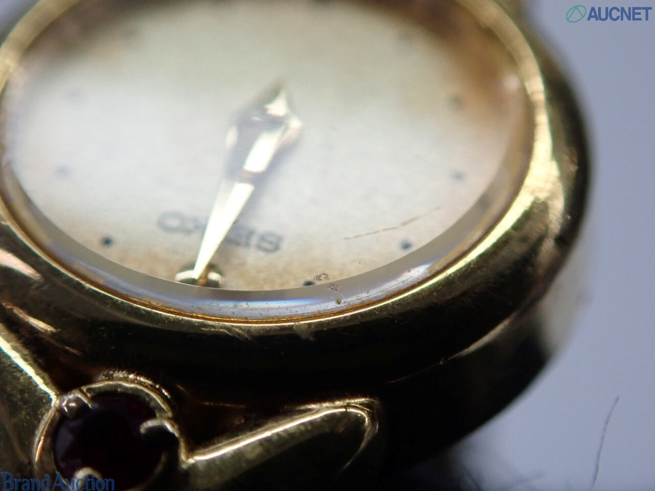 Orologio da donna Seiko color oro visto dal retro: fondello in acciaio, pietre rosse sulle anse, bracciale a catena — vista 5