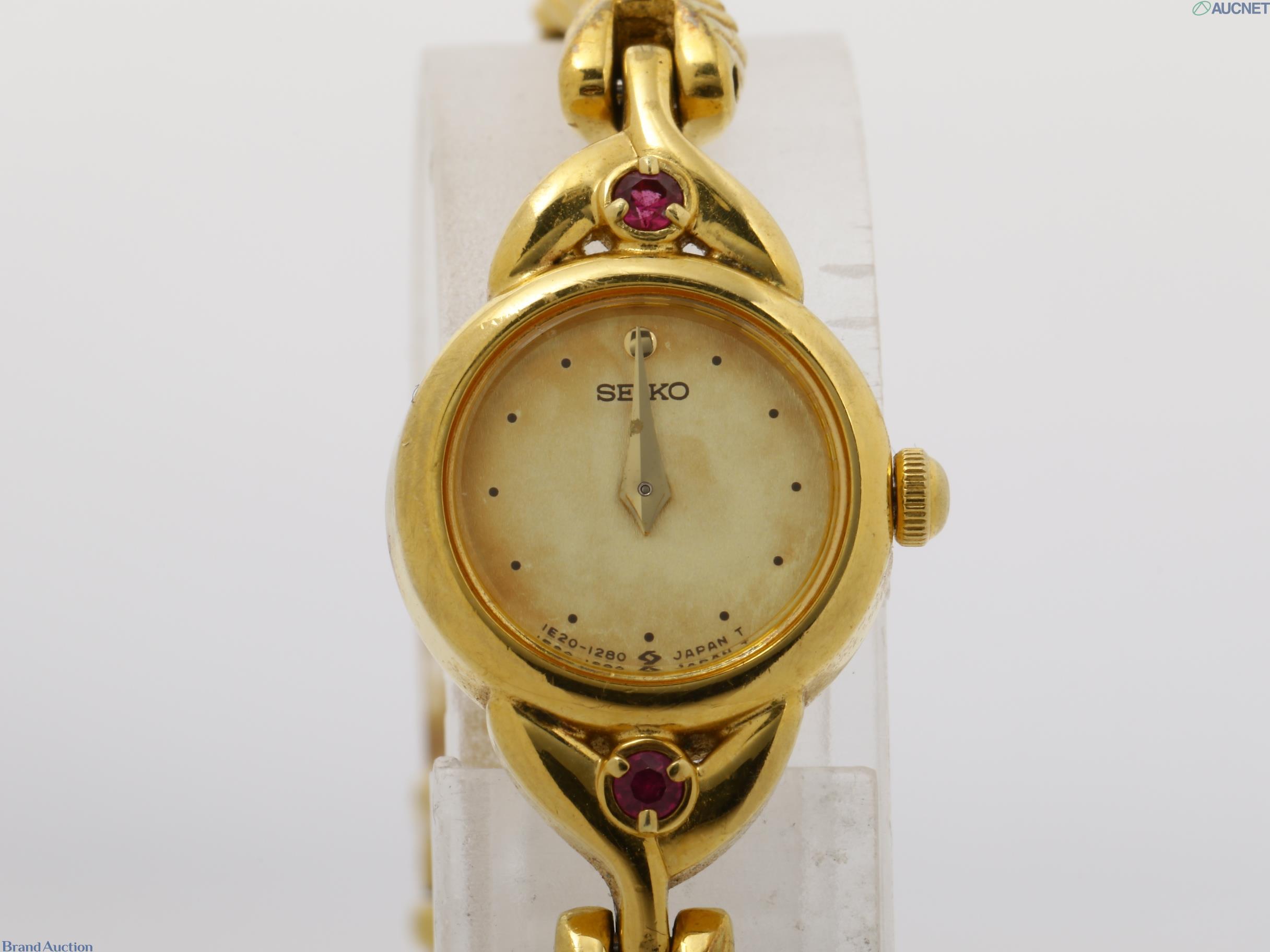Orologio da donna Seiko color oro visto dal retro: fondello in acciaio, pietre rosse sulle anse, bracciale a catena — vista 6