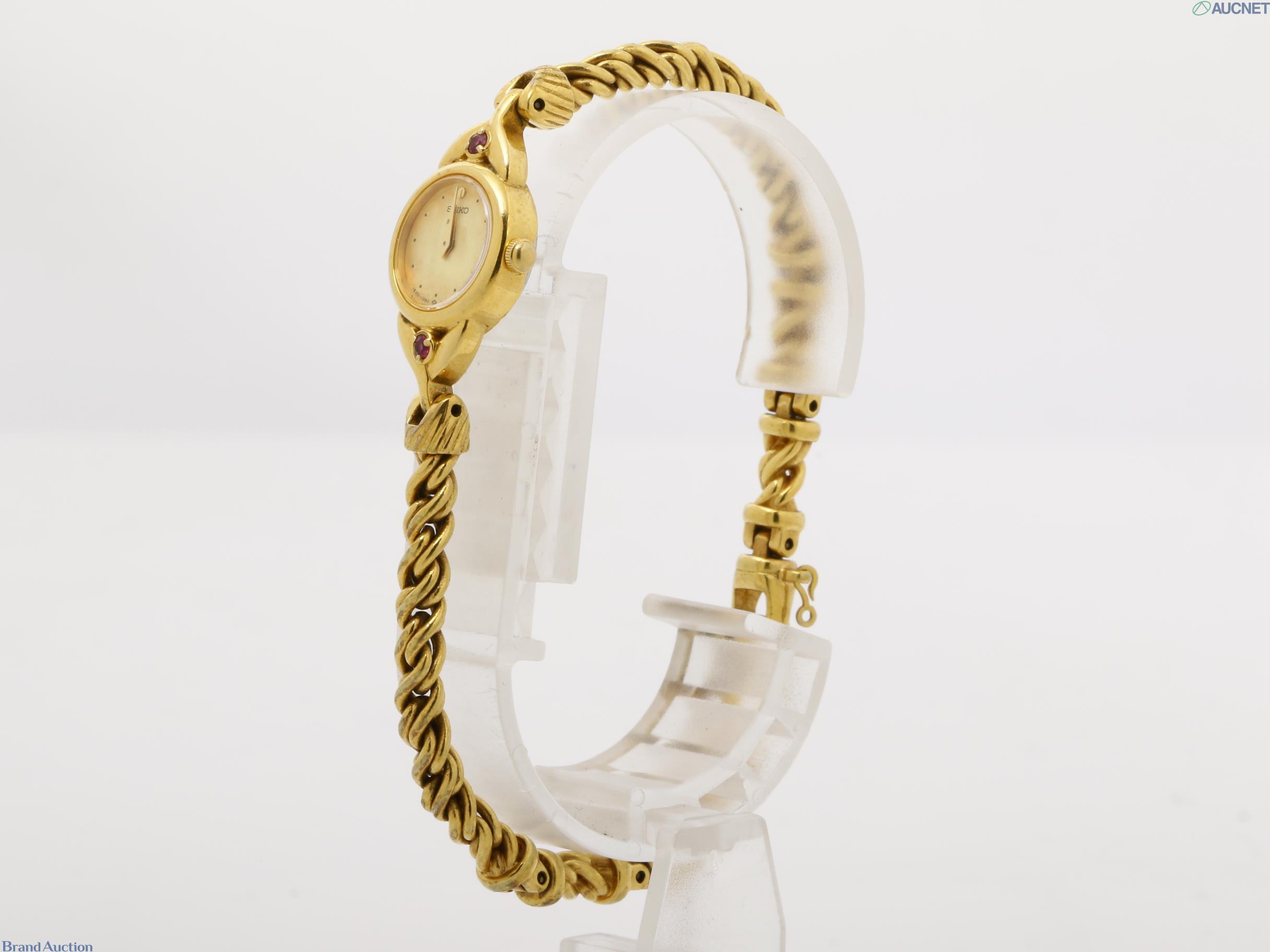 Orologio da donna Seiko color oro visto dal retro: fondello in acciaio, pietre rosse sulle anse, bracciale a catena — vista 7