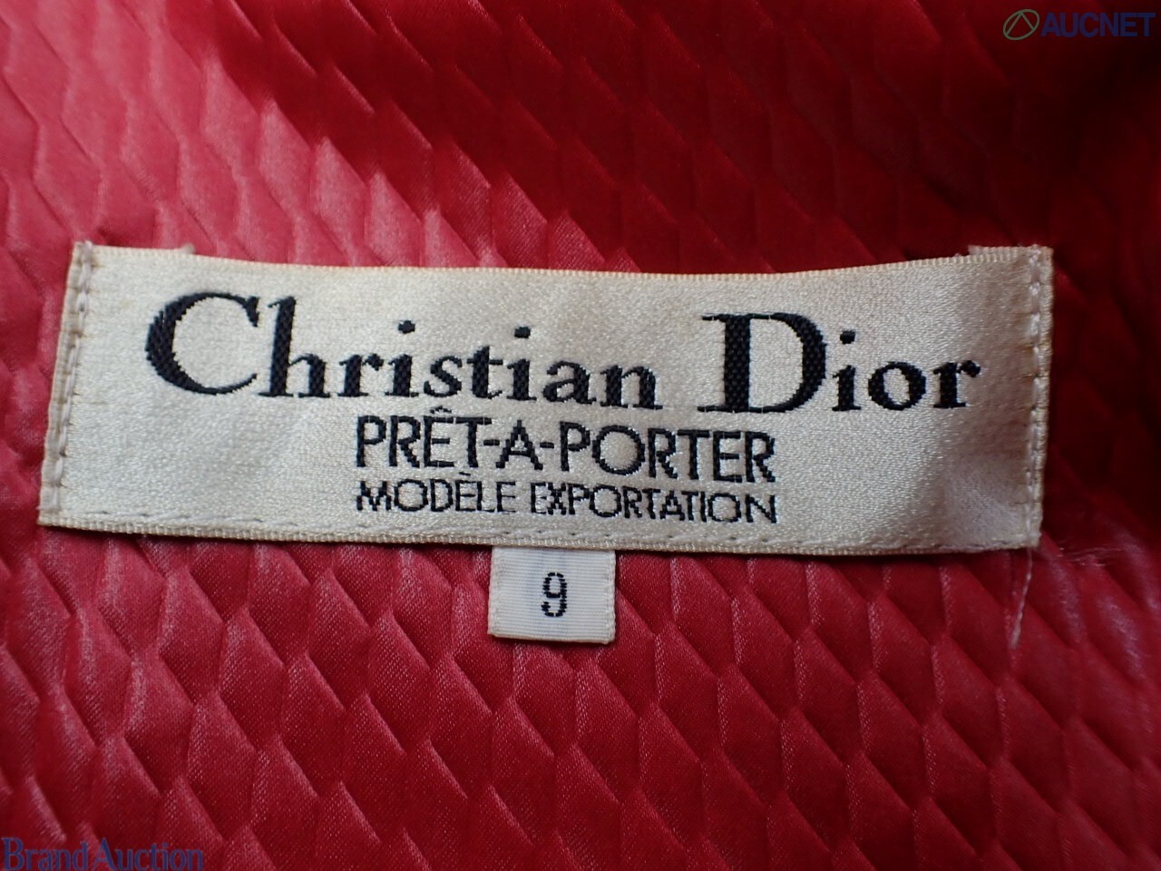 Cappotto rosso Christian Dior in tessuto goffrato su manichino, colletto a camicia e spalle arricciate, vista frontale — vista 4