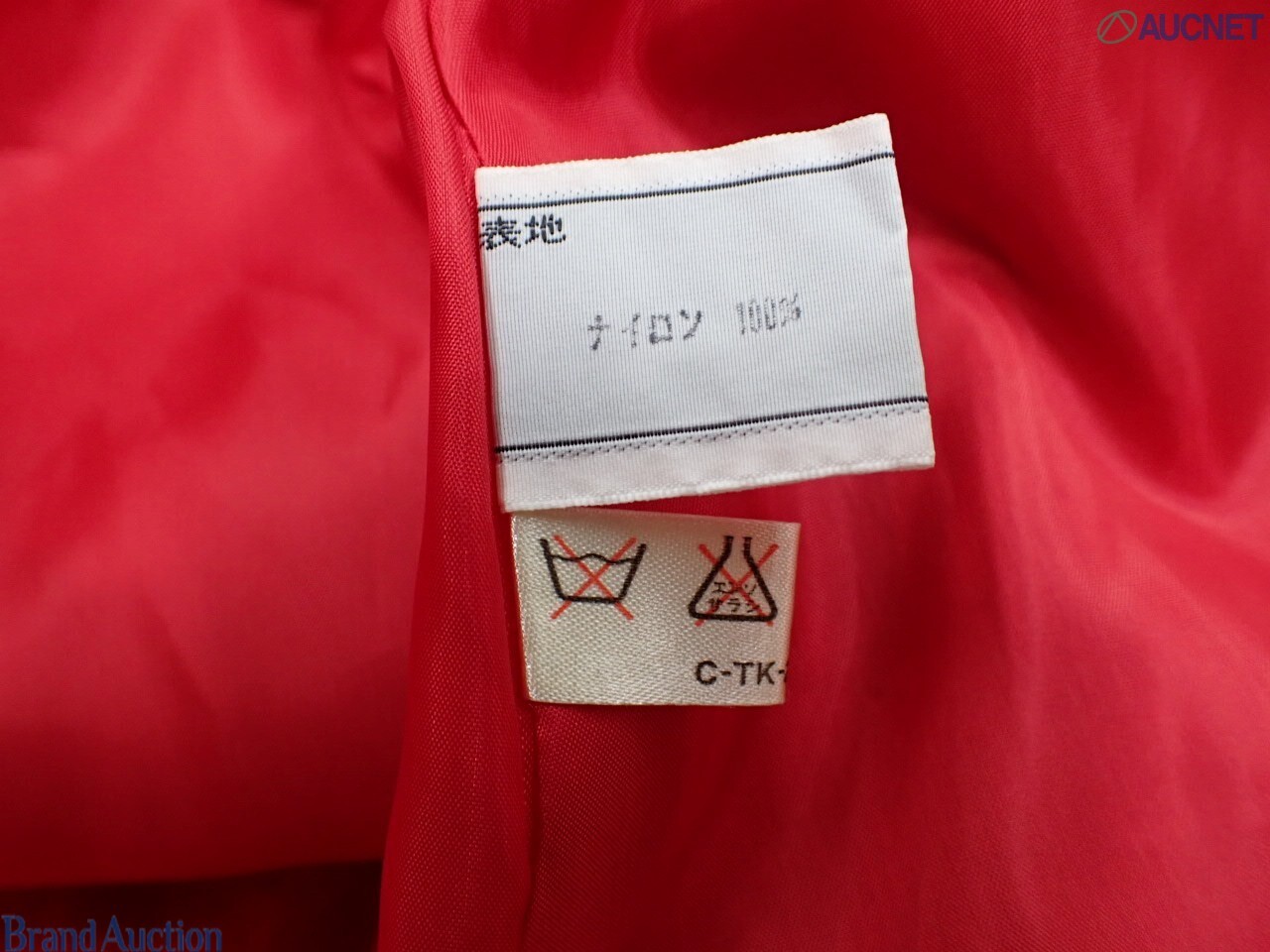 Cappotto rosso Christian Dior in tessuto goffrato su manichino, colletto a camicia e spalle arricciate, vista frontale — vista 5