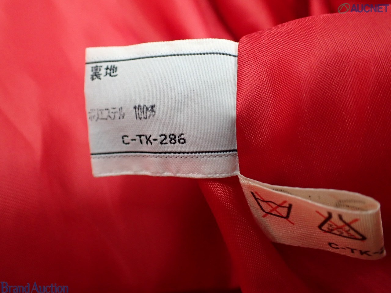 Cappotto rosso Christian Dior in tessuto goffrato su manichino, colletto a camicia e spalle arricciate, vista frontale — vista 6