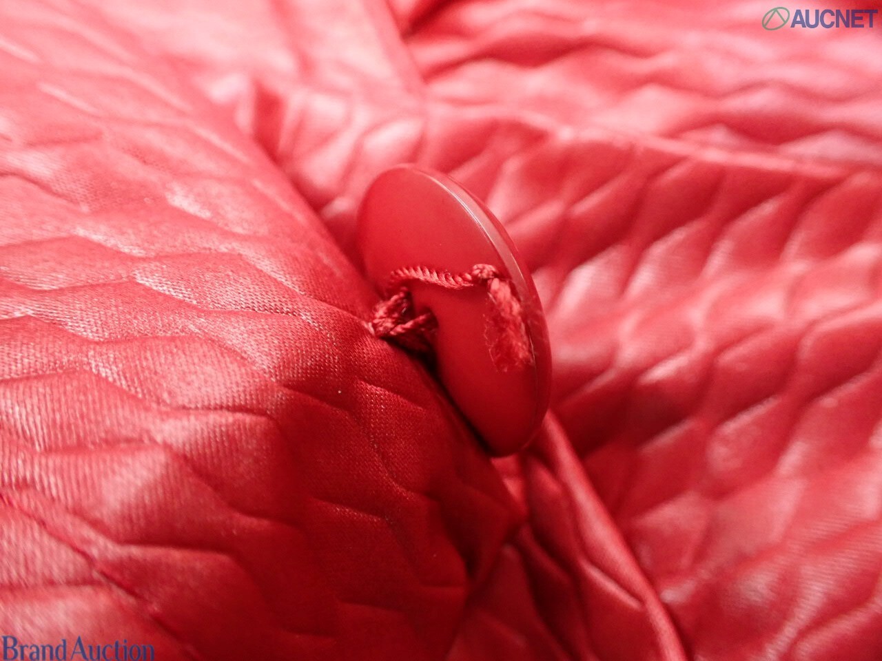 Cappotto rosso Christian Dior in tessuto goffrato su manichino, colletto a camicia e spalle arricciate, vista frontale — vista 8