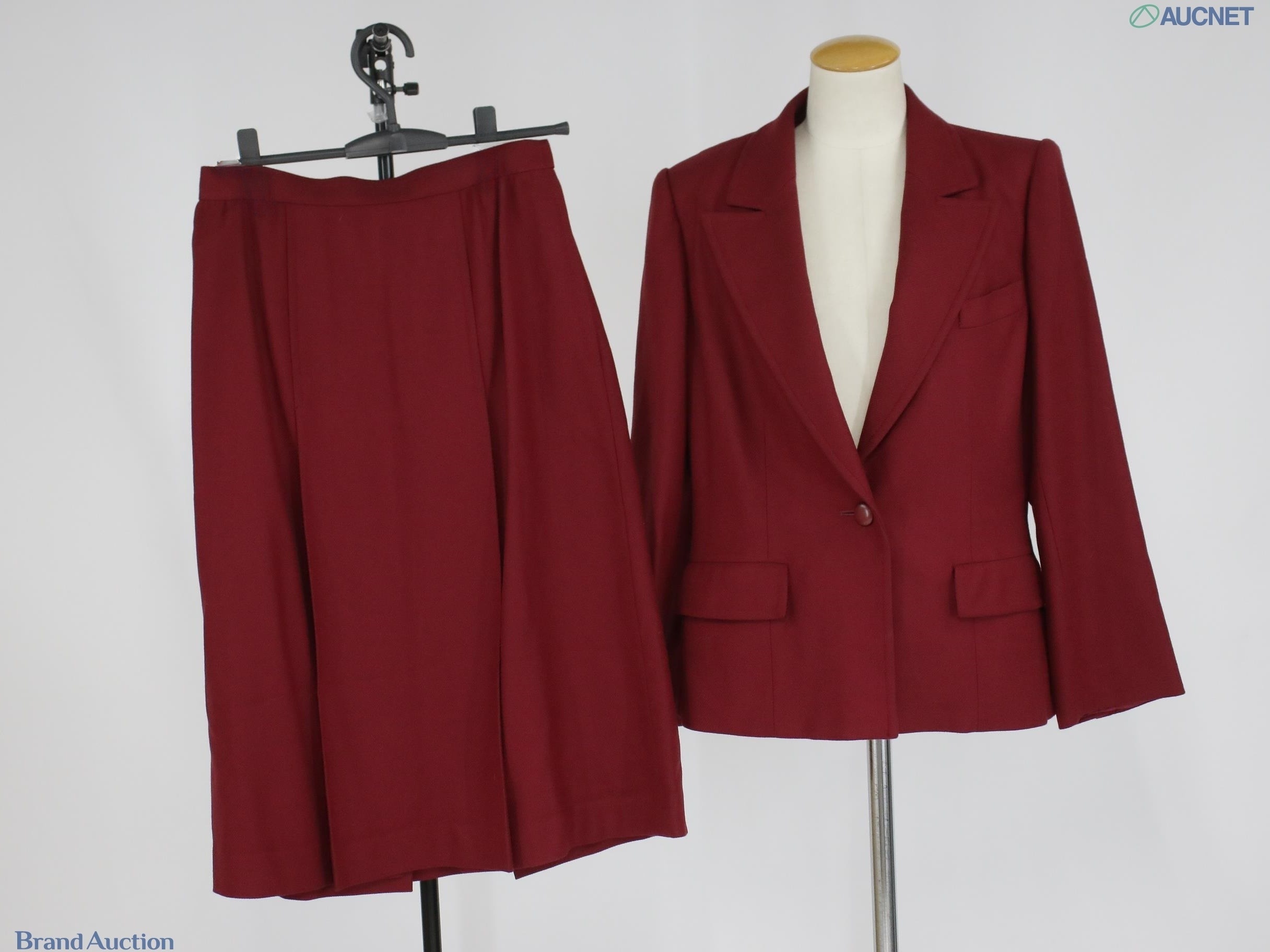 Tailleur bordeaux Christian Dior: giacca monopetto a un bottone su manichino e gonna su gruccia, vista frontale