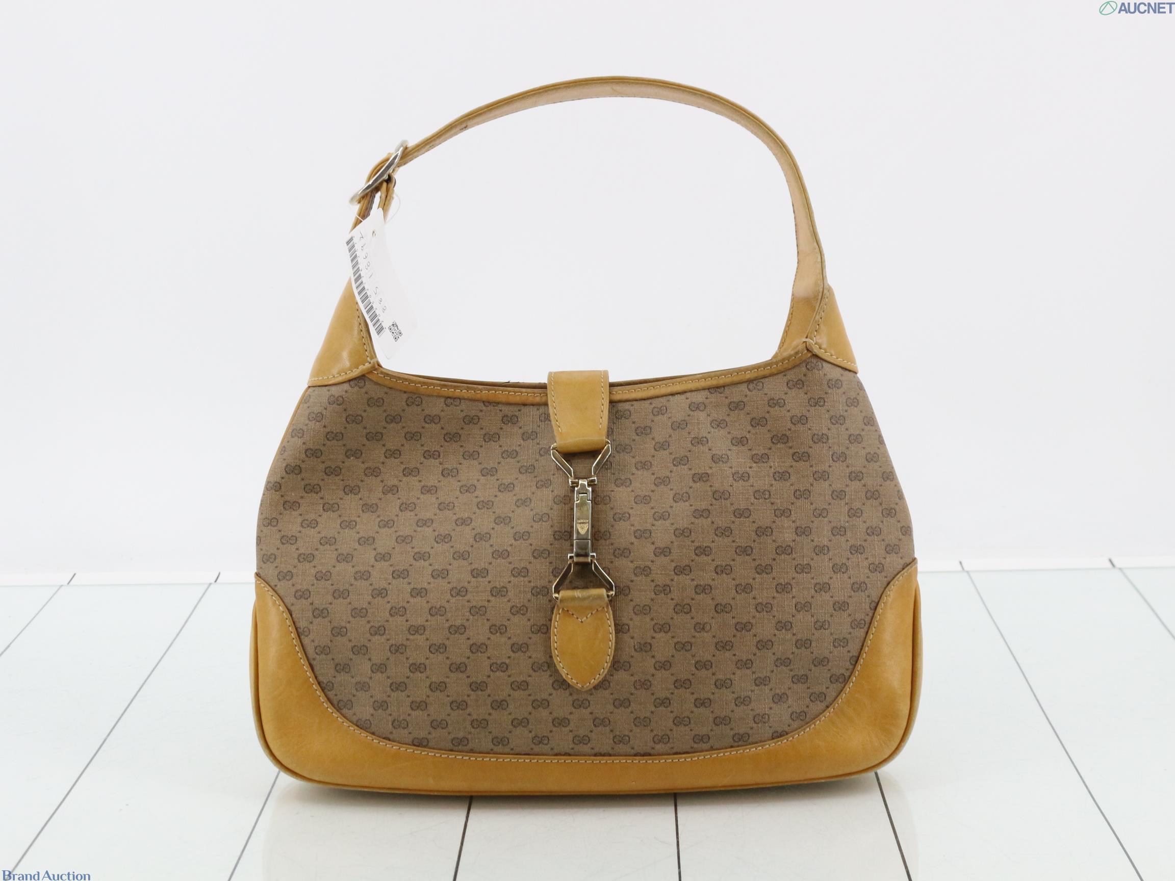 Borsa Gucci con micro motivo GG su fondo beige, finiture color miele e chiusura a pistone dorata, vista frontale