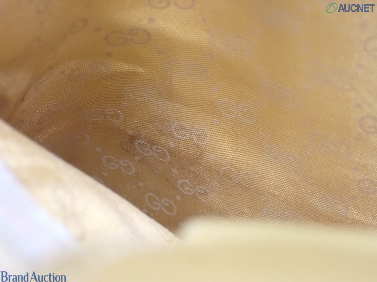 Borsa Gucci con micro motivo GG su fondo beige, finiture color miele e chiusura a pistone dorata, vista frontale — vista 17