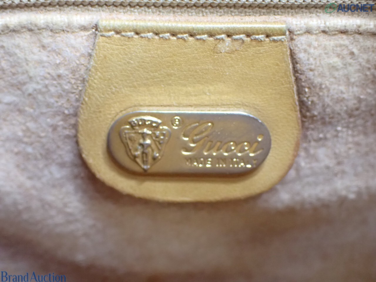 Borsa Gucci con micro motivo GG su fondo beige, finiture color miele e chiusura a pistone dorata, vista frontale — vista 25