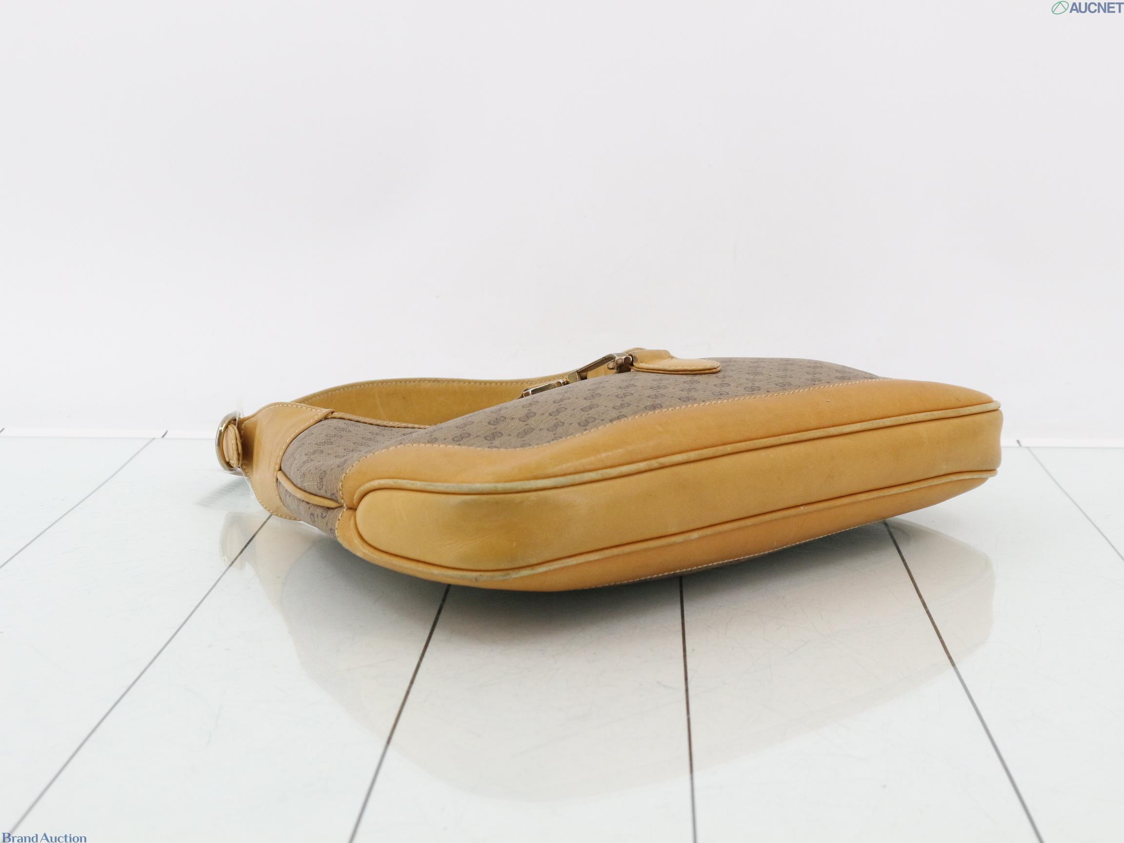 Borsa Gucci con micro motivo GG su fondo beige, finiture color miele e chiusura a pistone dorata, vista frontale — vista 5