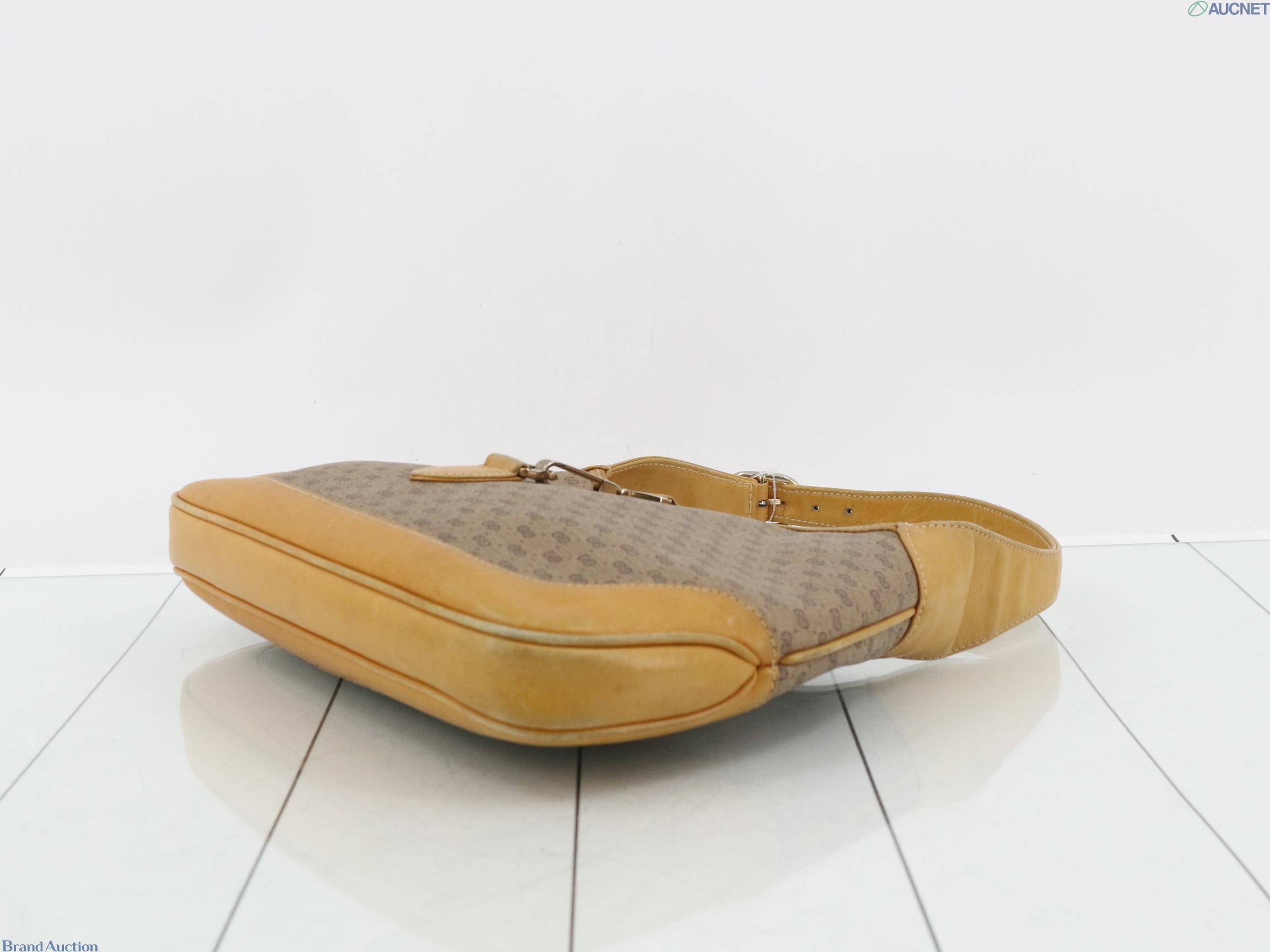 Borsa Gucci con micro motivo GG su fondo beige, finiture color miele e chiusura a pistone dorata, vista frontale — vista 6
