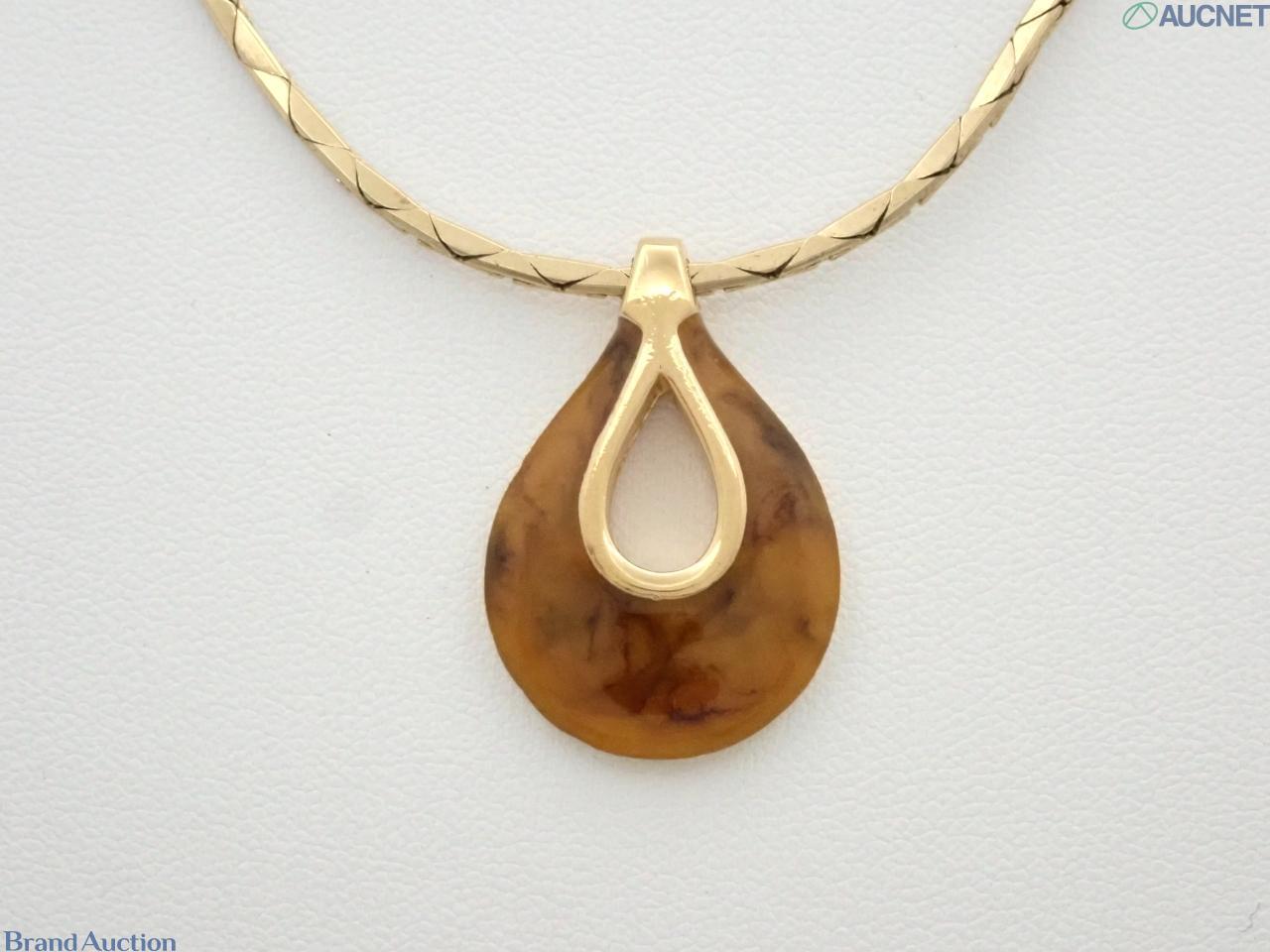 Collana Givenchy a catena dorata piatta con pendente a goccia color ambra marmorizzato e ansa dorata aperta al centro.