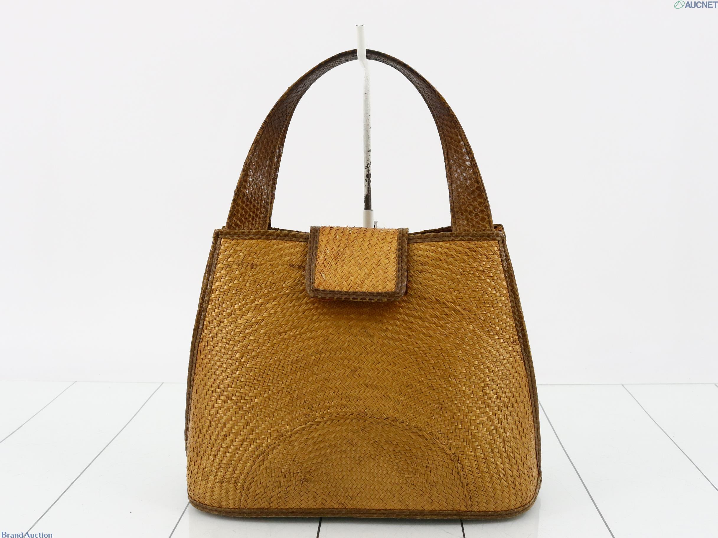 Borsa a mano in intreccio color miele, due manici bruni a scaglie e patta centrale, vista di fronte su fondo bianco