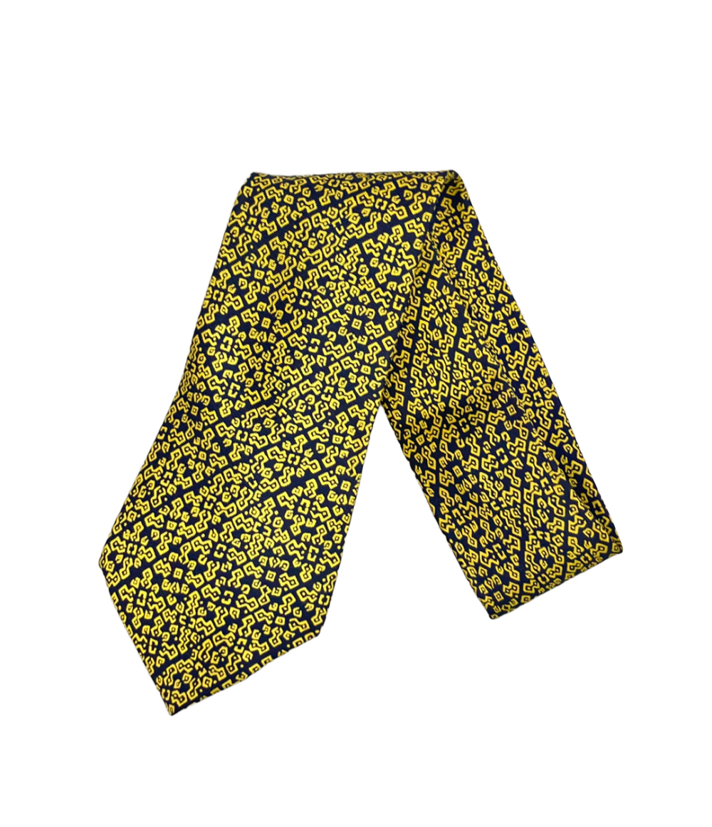Cravatta Hermès in seta blu notte con motivo geometrico giallo a bande diagonali, ripiegata su fondo bianco