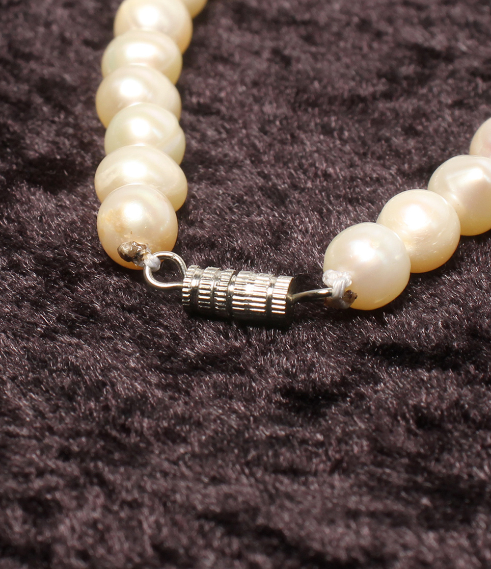Collana a filo unico di perle d'acqua dolce chiare con chiusura a vite argentata, su velluto scuro — vista 4