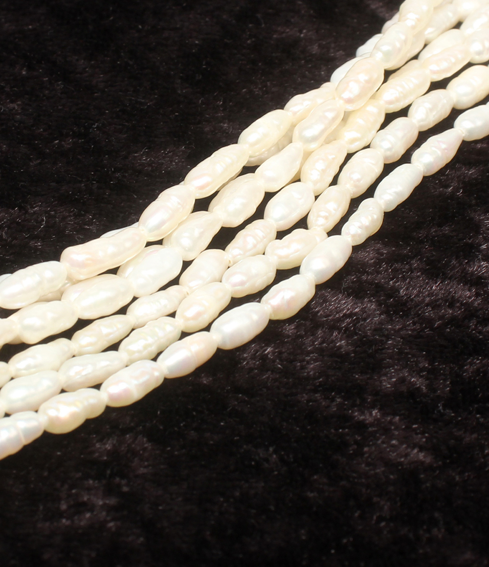 Collana a più fili di perline bianche a chicco di riso su velluto scuro, con fermaglio tondo lavorato a foglie color argento. — vista 6