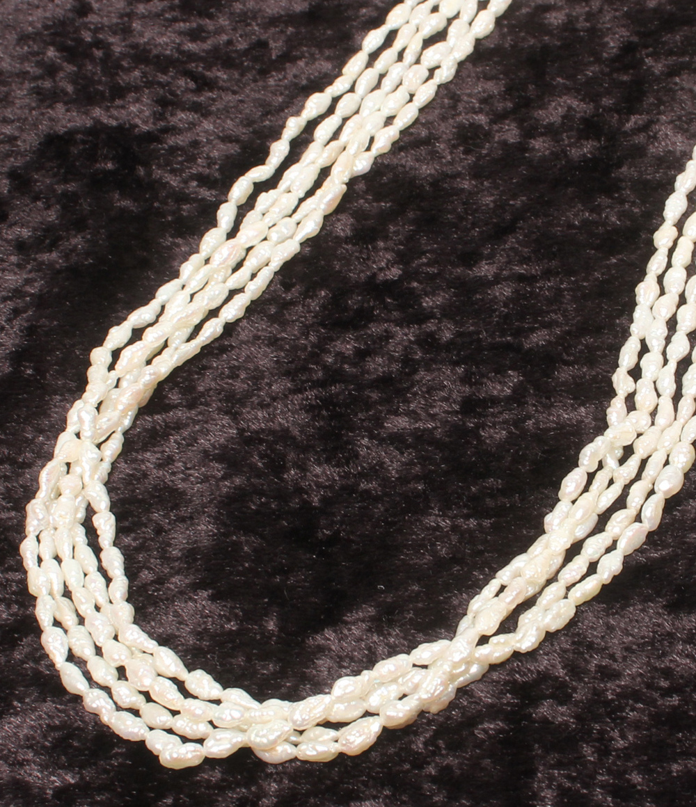Collana lunga a più fili di perline bianche a chicco di riso, con fermaglio rettangolare inciso e una piccola perla.