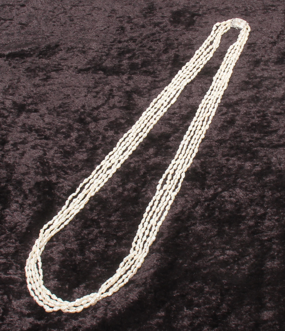 Collana lunga a più fili di perline bianche a chicco di riso, con fermaglio rettangolare inciso e una piccola perla. — vista 2