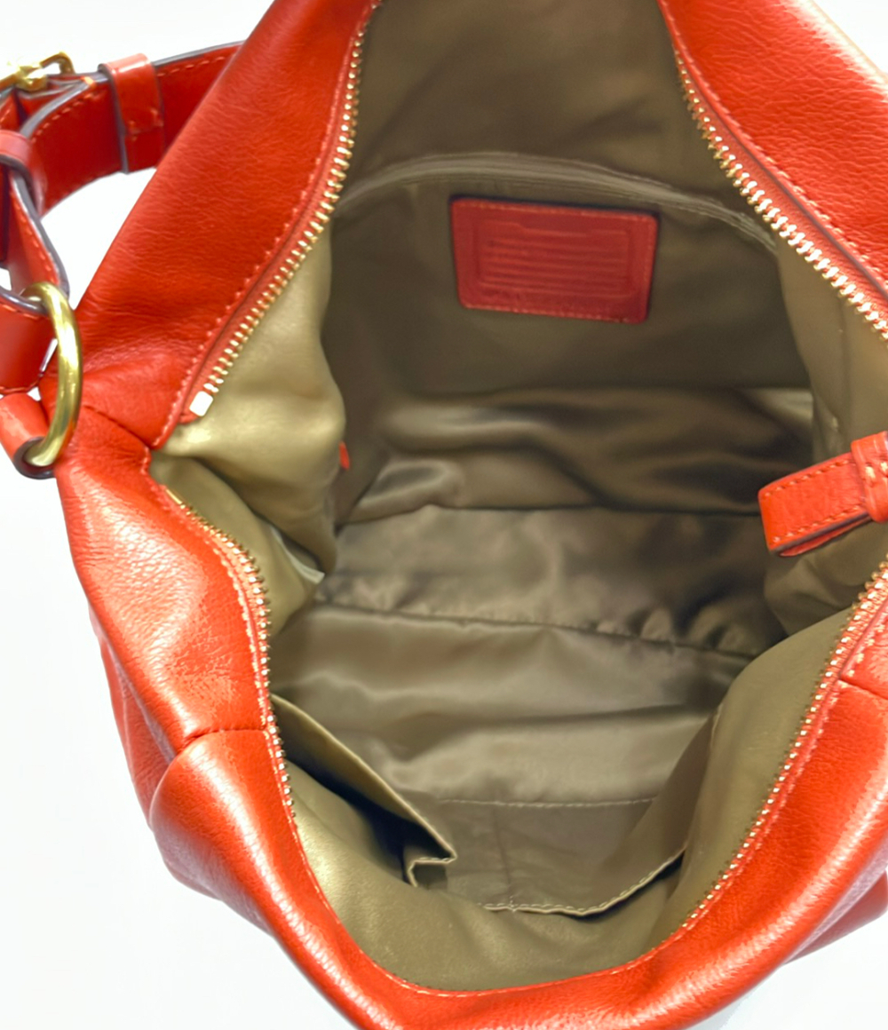 Borsa a spalla Coach in pelle color mattone, morbida, con manico regolabile a fibbia dorata e targhetta con la carrozza. — vista 5