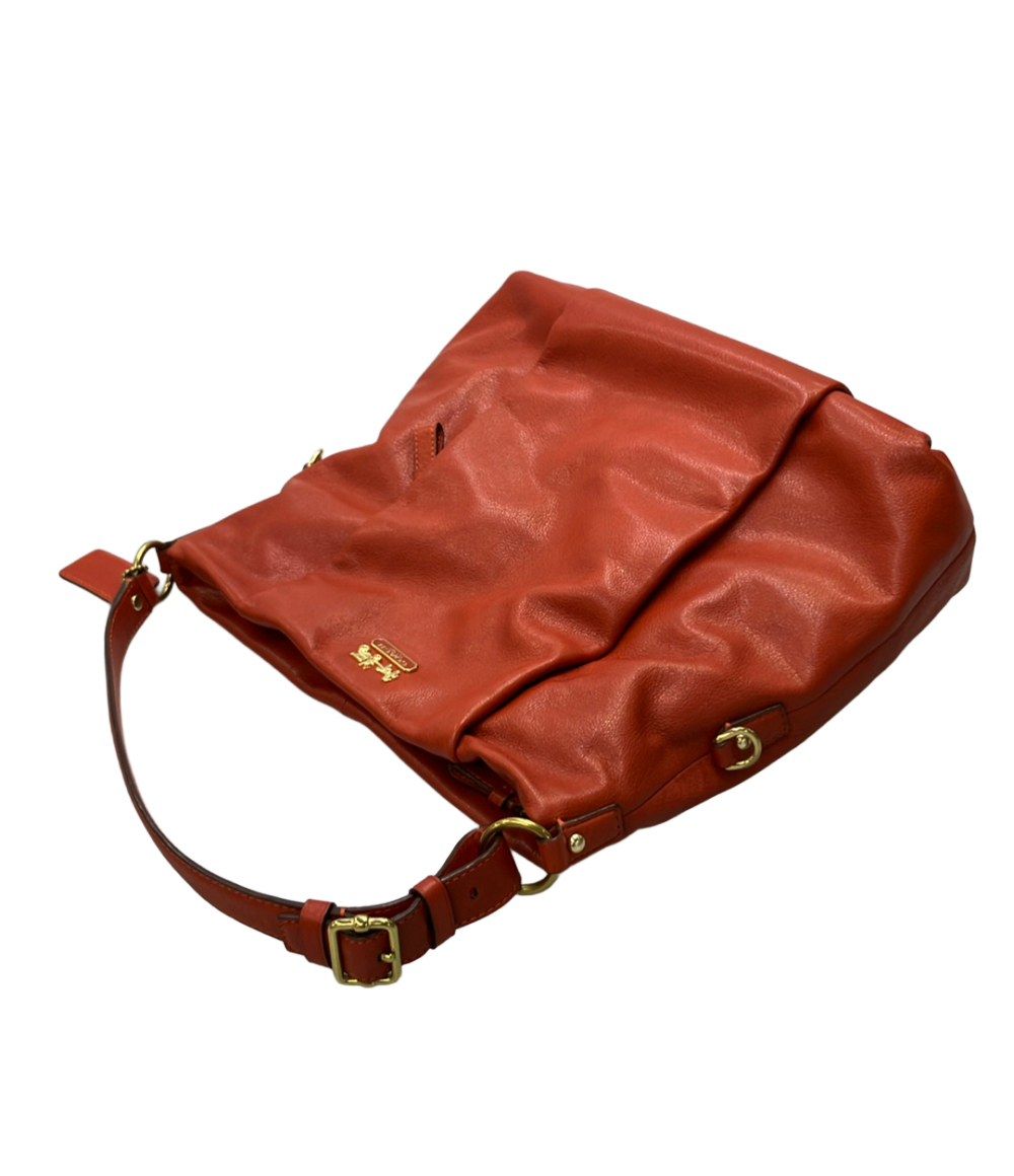 Borsa a spalla Coach in pelle color mattone, morbida, con manico regolabile a fibbia dorata e targhetta con la carrozza. — vista 7