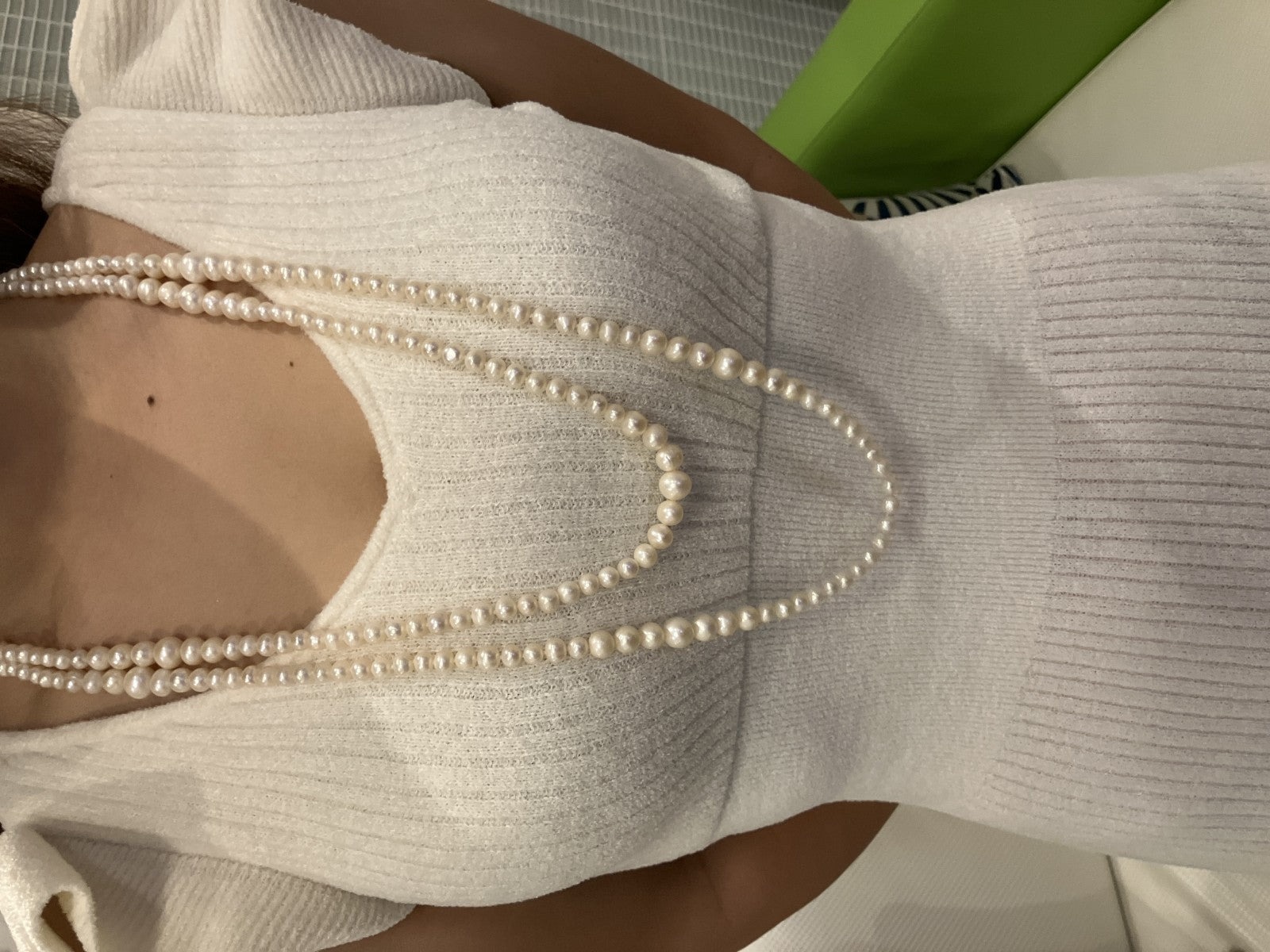 Collana lunga di perle bianche di misura alternata, indossata a doppio giro su un abito bianco a coste — vista 4