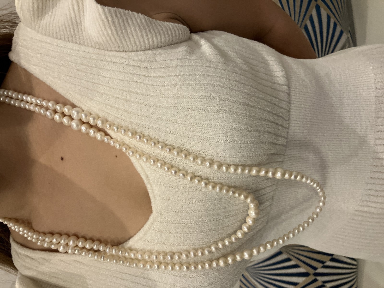 Collana lunga di perle bianche di misura alternata, indossata a doppio giro su un abito bianco a coste — vista 5