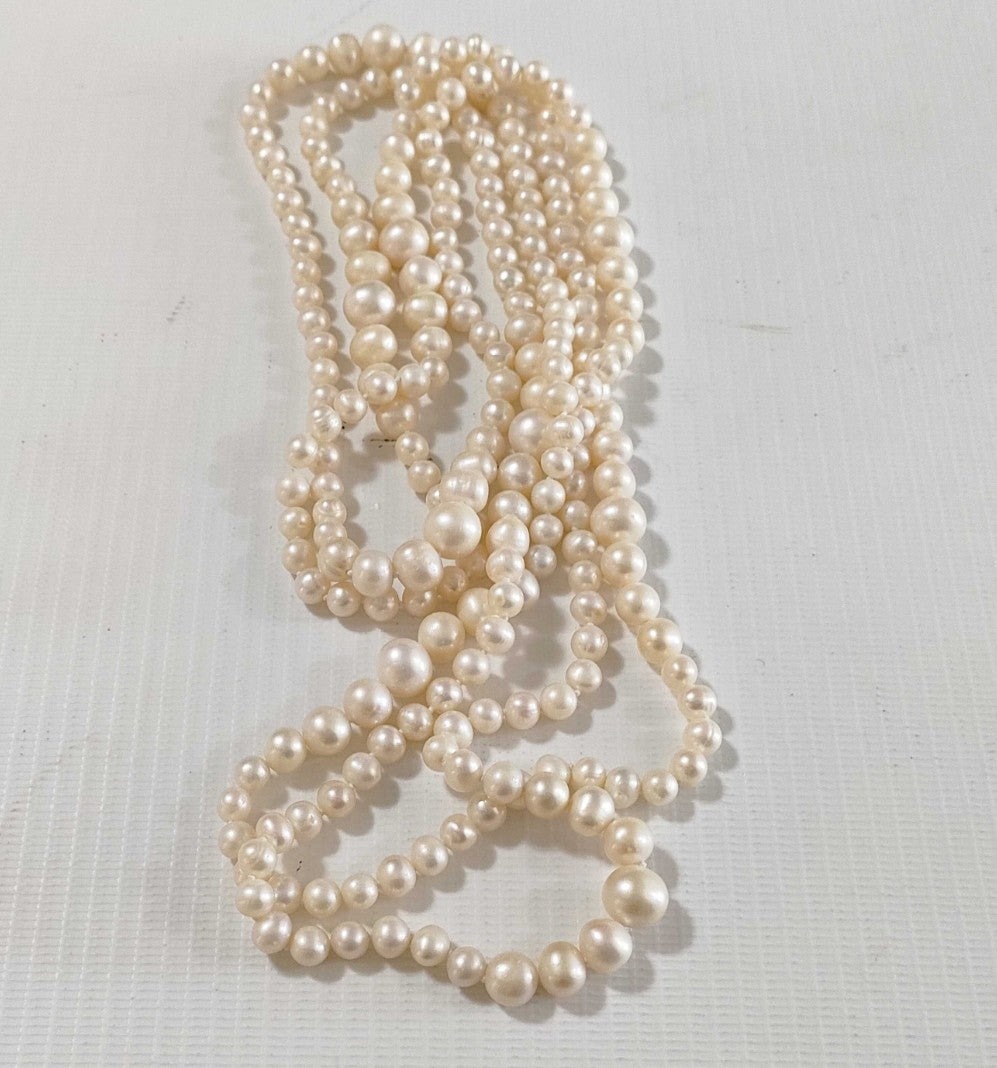 Collana lunga di perle bianche di misura alternata, indossata a doppio giro su un abito bianco a coste — vista 6