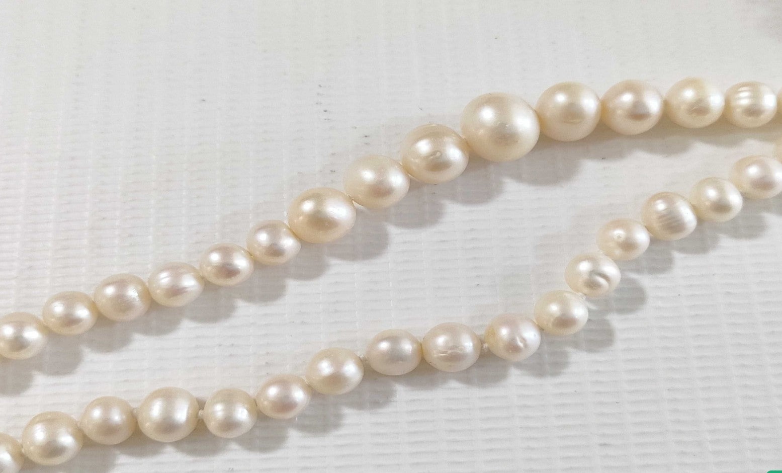 Collana lunga di perle bianche di misura alternata, indossata a doppio giro su un abito bianco a coste — vista 10