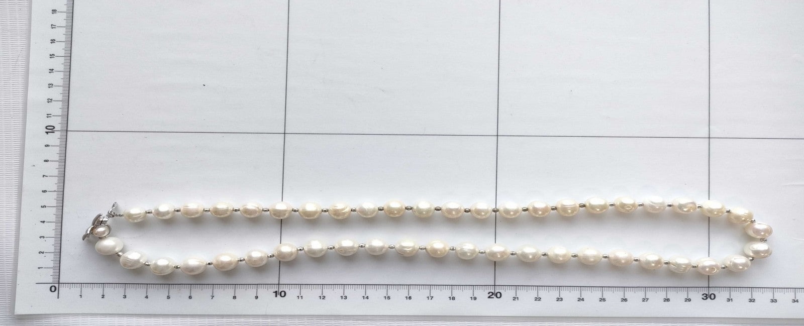 Collana di perle coltivate bianche con piccoli distanziatori argentati, indossata su un maglione rosa chiaro — vista 2