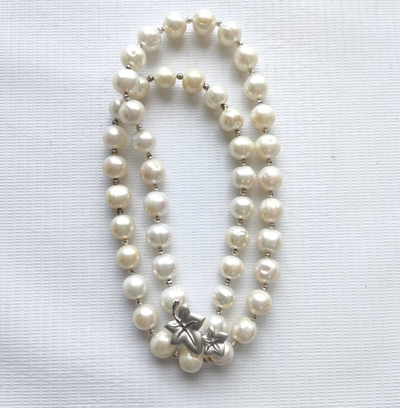 Collana di perle coltivate bianche con piccoli distanziatori argentati, indossata su un maglione rosa chiaro — vista 3