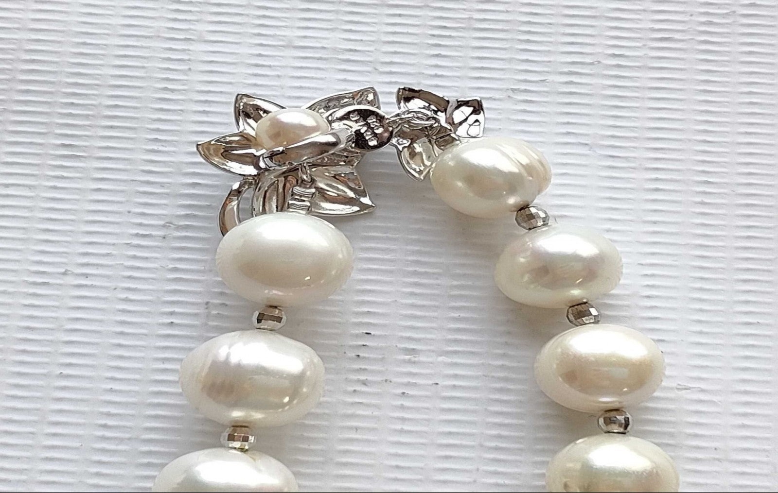 Collana di perle coltivate bianche con piccoli distanziatori argentati, indossata su un maglione rosa chiaro — vista 4