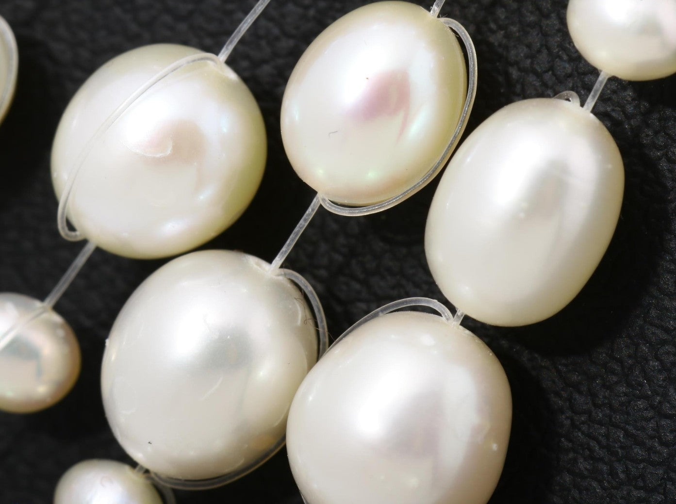 Collana a cinque fili di perle bianche d'acqua dolce su filo trasparente, a cascata, indossata su un maglione nero — vista 8