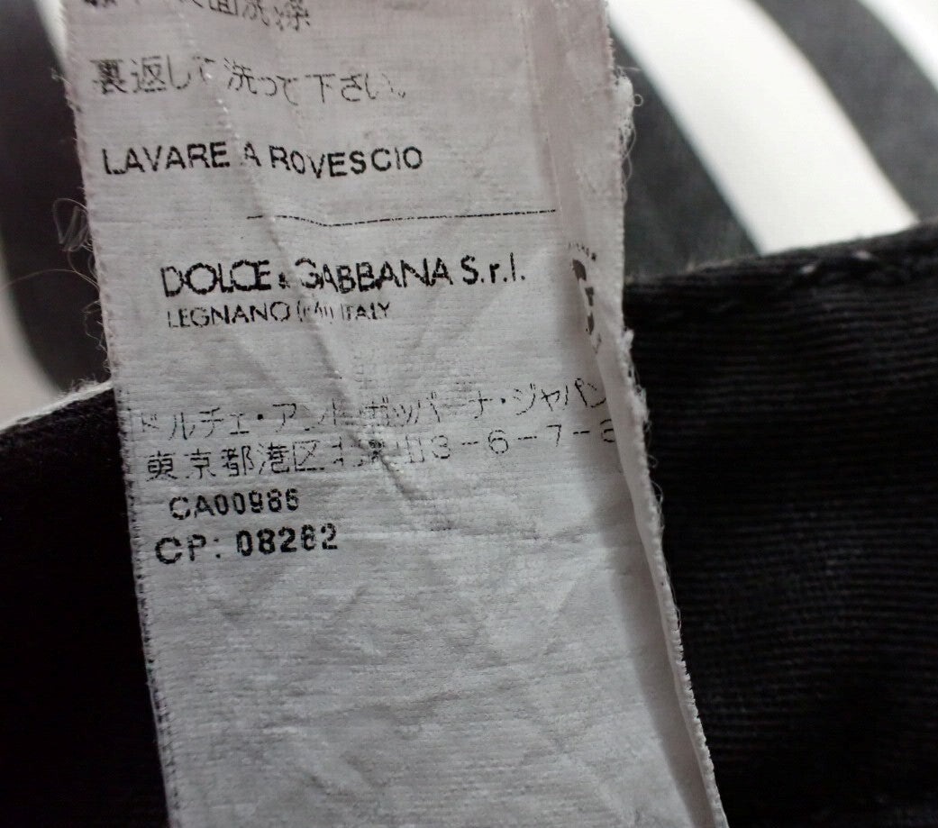Pantaloni aderenti Dolce&Gabbana a righe verticali nere e bianche, indossati, con bottone in vita e tasche anteriori. — vista 2