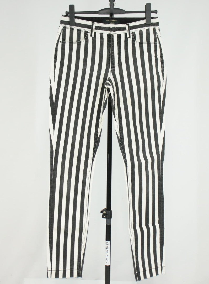 Pantaloni aderenti Dolce&Gabbana a righe verticali nere e bianche, indossati, con bottone in vita e tasche anteriori. — vista 3