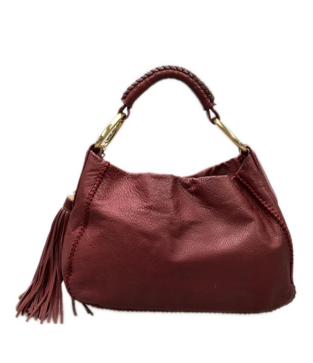 Borsa a spalla Sazaby bordeaux, morbida, con manico intrecciato, anelli dorati e lunga nappa a frange.