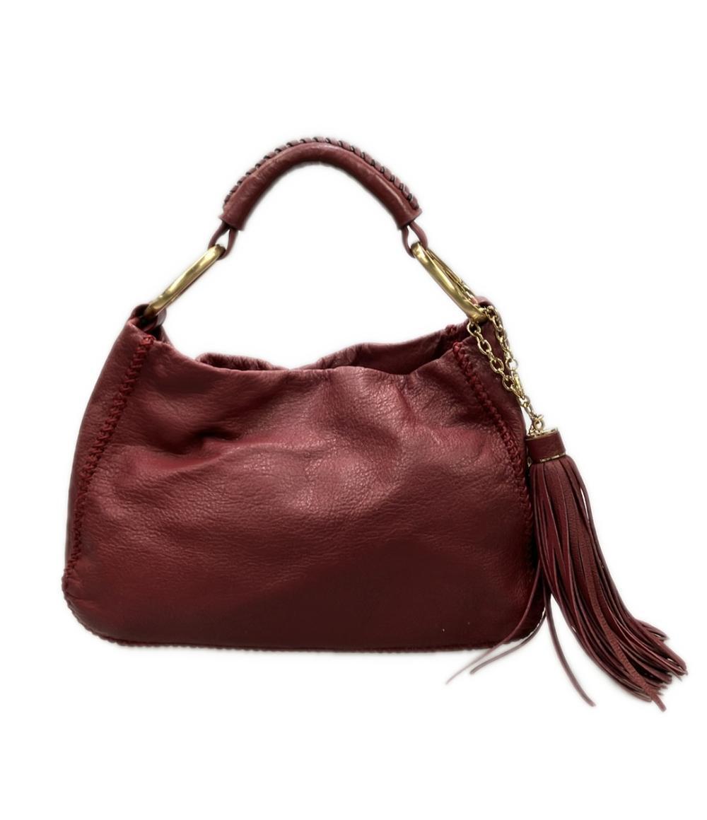 Borsa a spalla Sazaby bordeaux, morbida, con manico intrecciato, anelli dorati e lunga nappa a frange. — vista 2